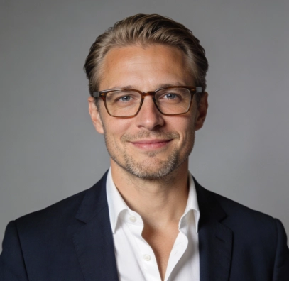 Professional headshot of a man with glasses