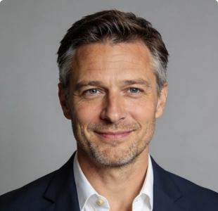 Professional headshot of a man with short hair in a dark blazer